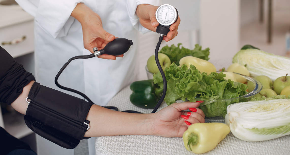 Doctor measures the pressure of the patient in the kitchen