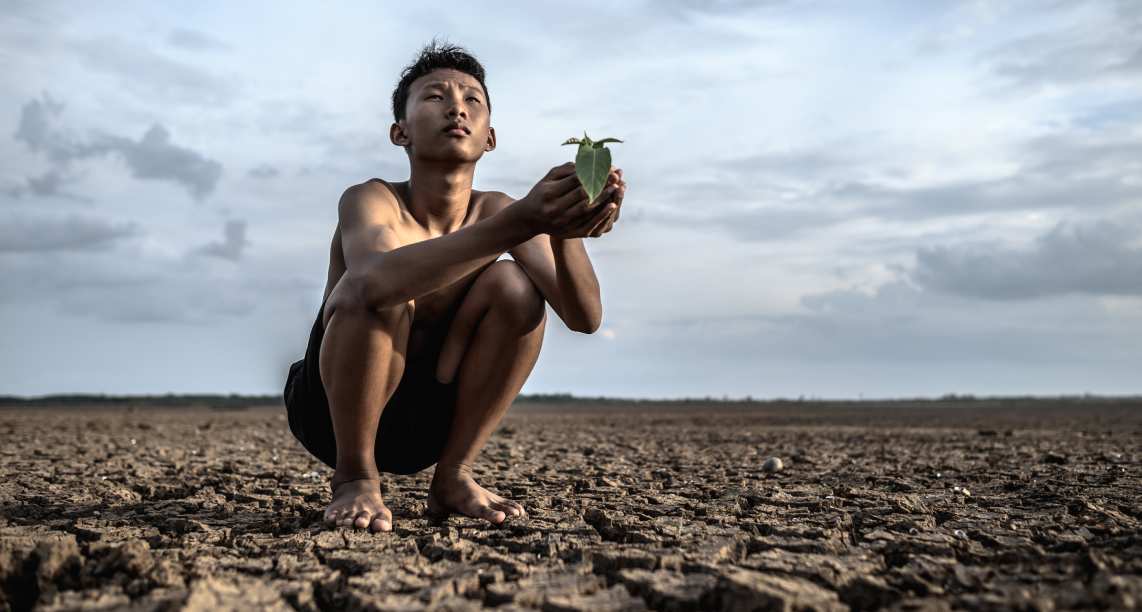 men-sit-in-their-hands-holding-seedlings-on-dry-ground-and-looking-at-the-sky (1)