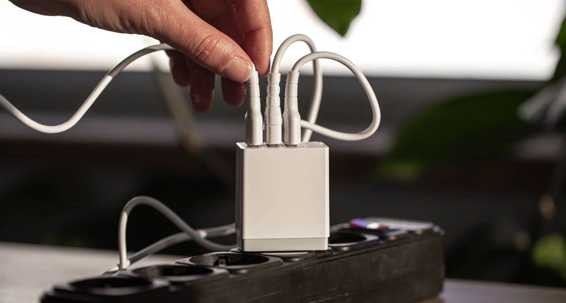 White USB charging for gadgets on a blurred background of the room, close-up.