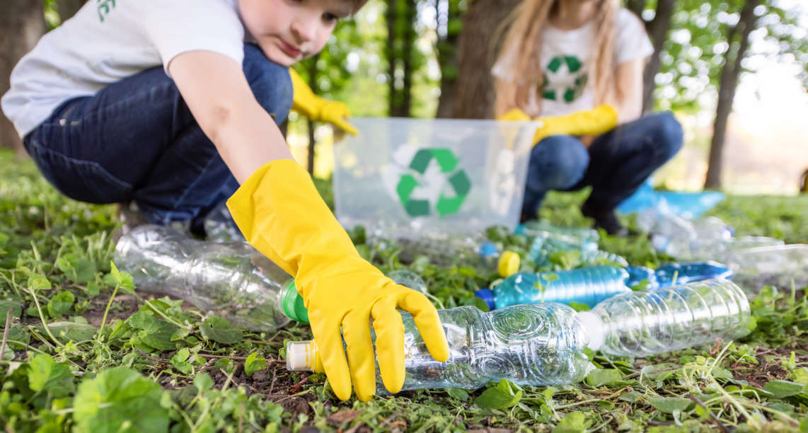 Boy and girl at plastic garbage collection in a park